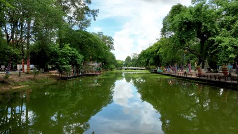 city traffic passing past urban river greenery, siem reap waterways