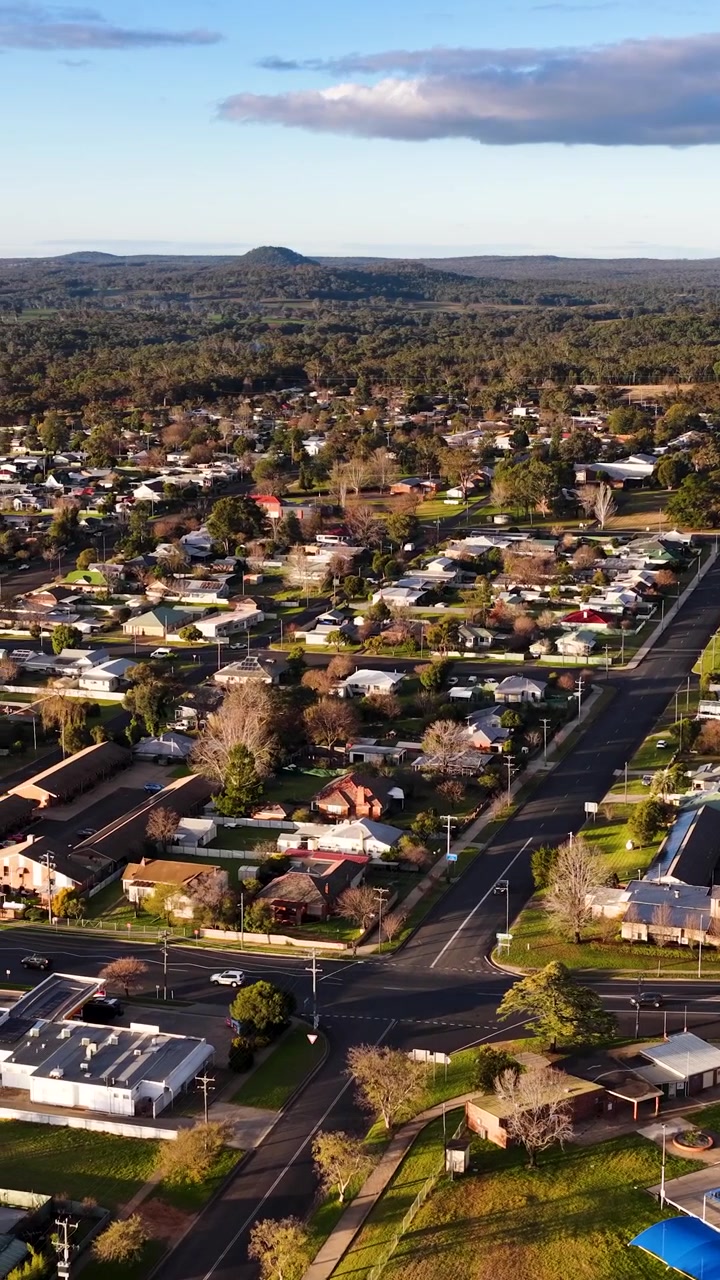 Ripresa drone dall'alto su case, strade e vegetazione a Coonabarabran, Nuovo Galles del Sud, Australia.