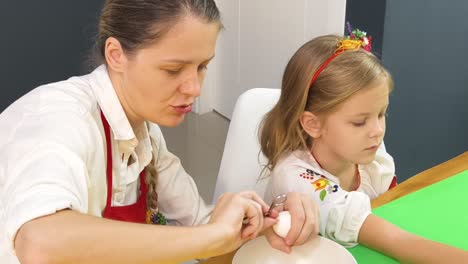 mother and daughter coloring easter eggs