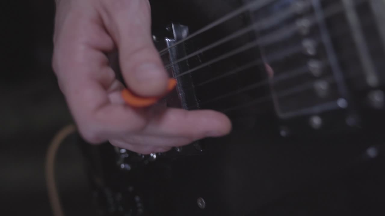 Close up on hands of person playing electric guitar