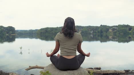 Mujer-Latina-Sentada-En-Pose-De-Meditación-Junto-Al-Agua