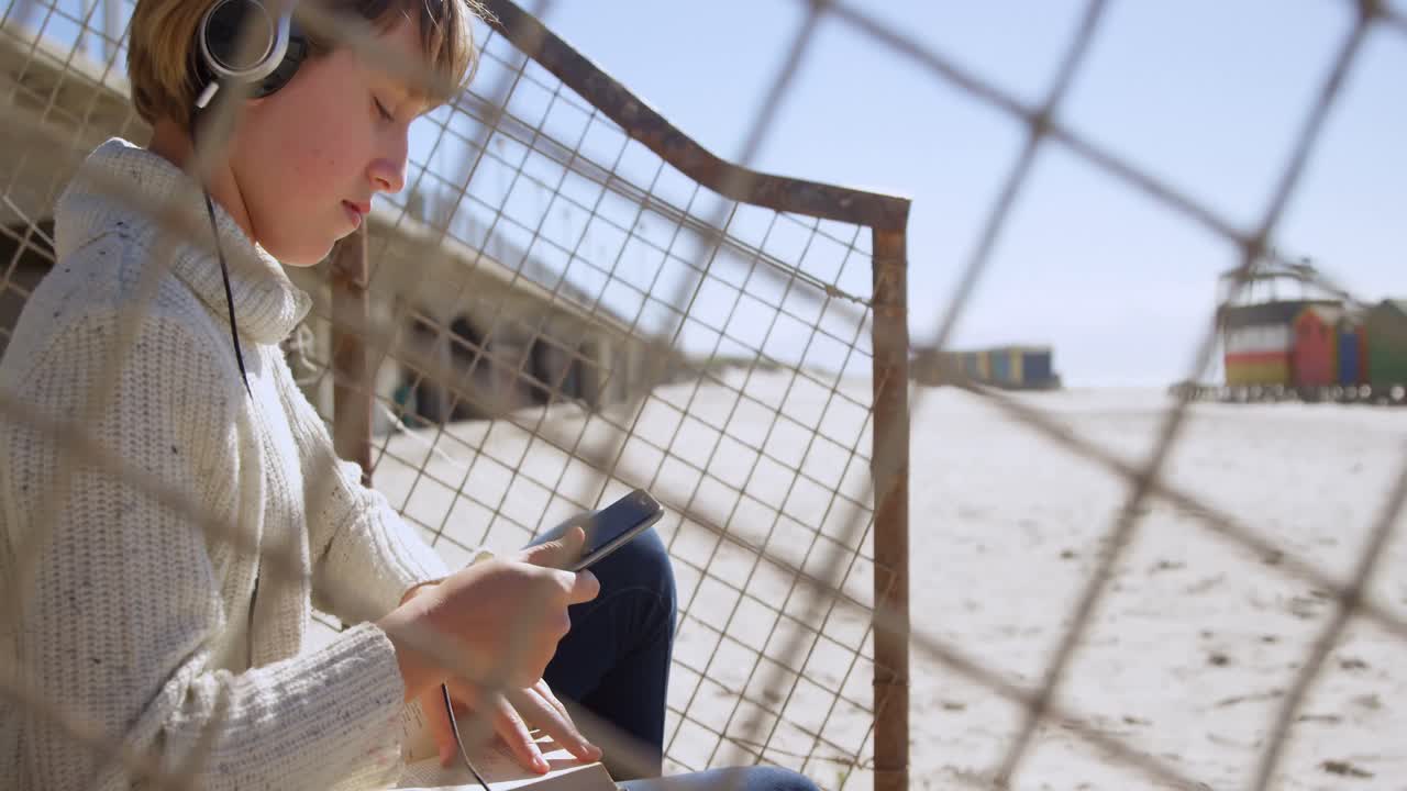 Girl using mobile phone at beach 4k