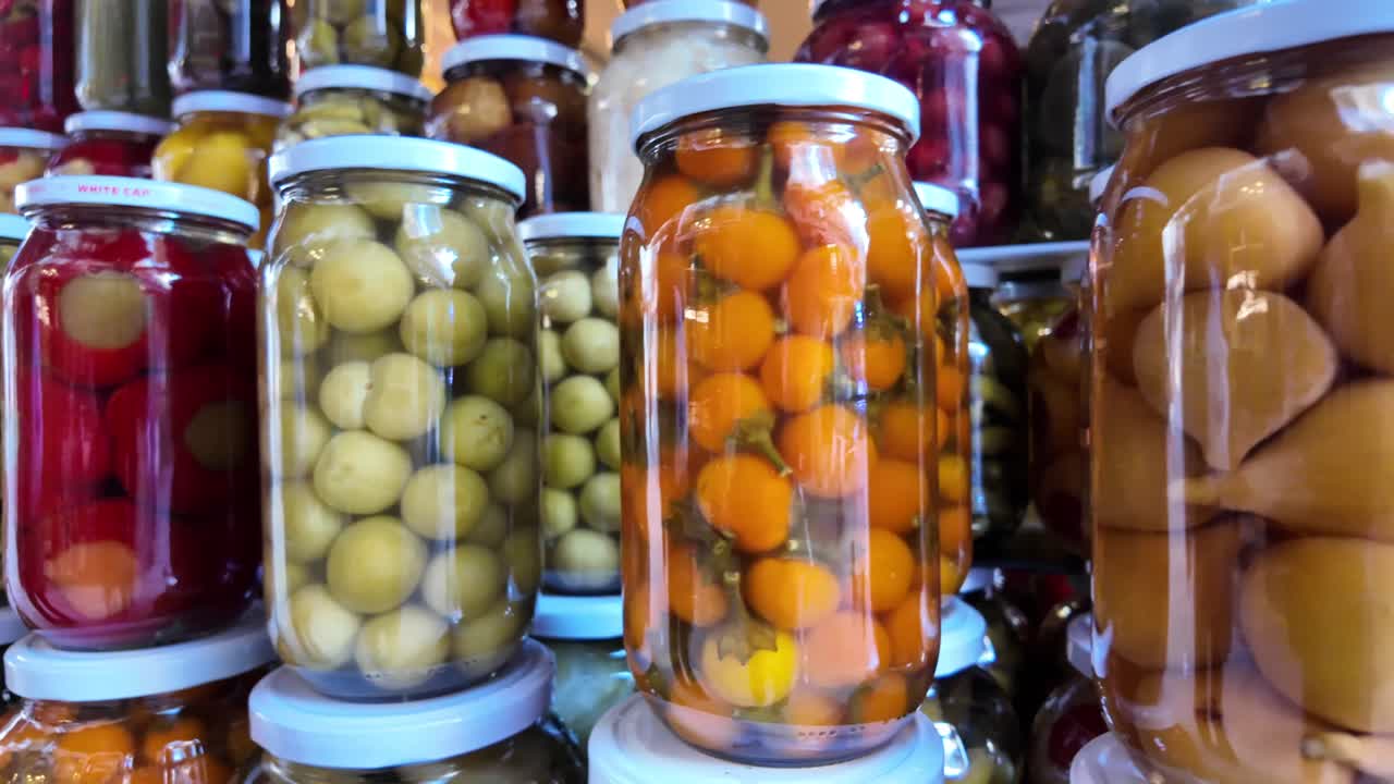 Surtido de verduras y frutas encurtidas de colores en frascos de vidrio.