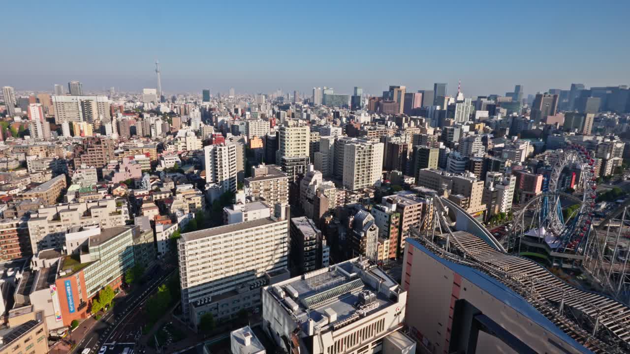 A sweeping aerial view of the vibrant Tokyo cityscape under a clear sky, featuring a sprawling urban jungle and an amusement park.