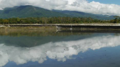 montañas nubladas reflejándose en arrozales inundados
