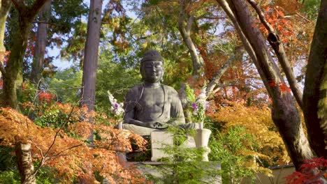 buddhist stone statue medium shot with fall colors in japan