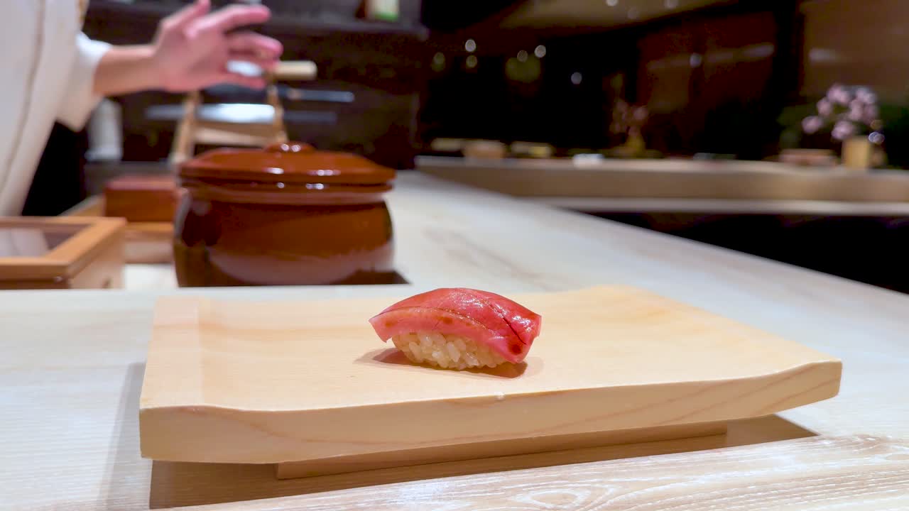 el chef coloca sushi en una tabla de madera.