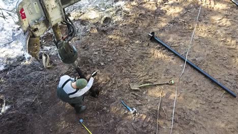 drilling a foundation post in the ground