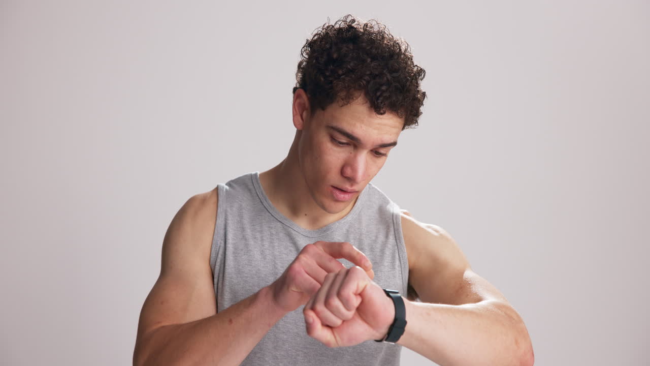Giovane uomo frustrato che controlla lo smartwatch e si gratta la testa