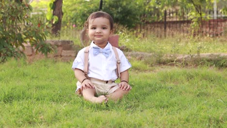 isolated cute baby boy toddler innocent smile in white cloth playing at park from flat angle