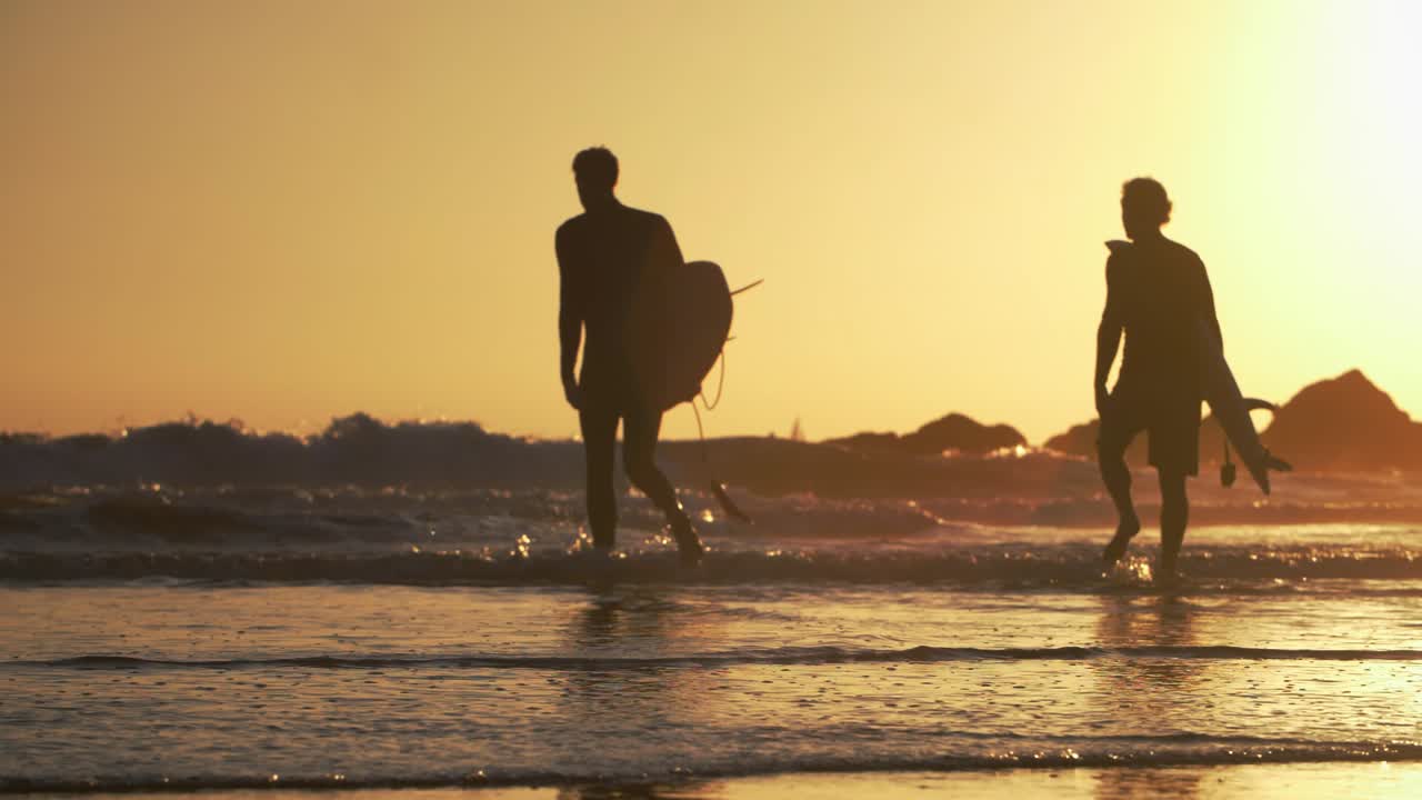 서퍼들이 바다로 걸어나간다