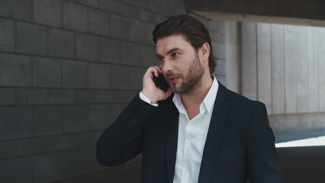 도시에서 스마트폰으로 이야기하는 사업가.  ⁇ 드폰을 사용하는 남성 직원