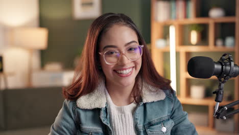 portrait of a smiling woman with glasses and microphone