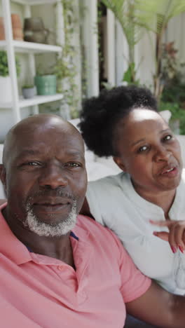 vertical video of portrait of happy senior african american couple having video call in slow motion