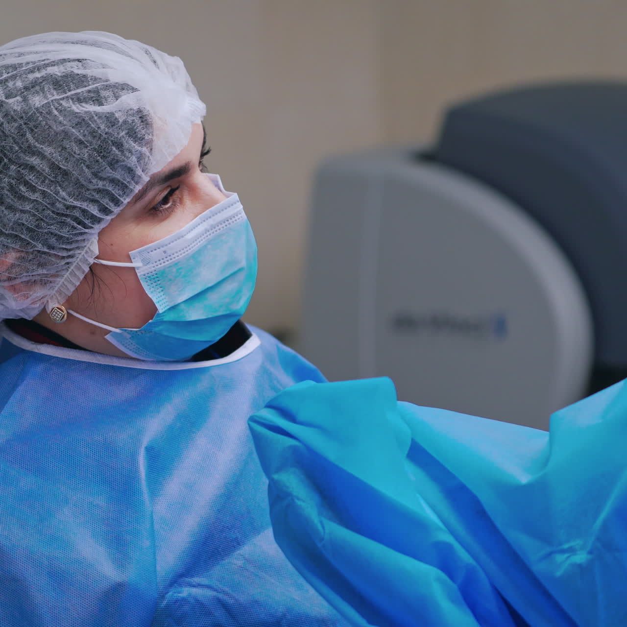 Woman assistant helps surgeon. Doctor together with a nurse use new medical equipment during laparoscopic surgery in the operating room.