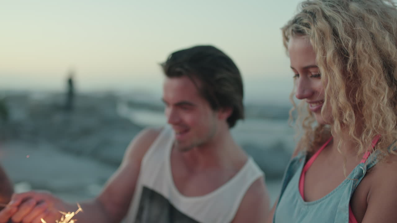 폭죽을 사용하여 해변에서 새해를 축하하는 유쾌한 친구들