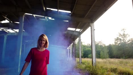 smooth slow motion cinematic shot of funny young girl in a red dresscolorful fog shooting russians tank hall hangar gimbal foto video shoot on lost places in wild nature 1080, 24p by philipp marnitz