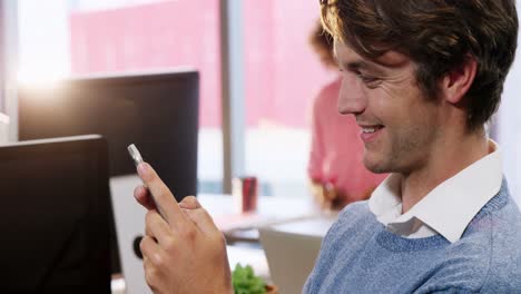 Businessman-using-mobile-phone-at-desk