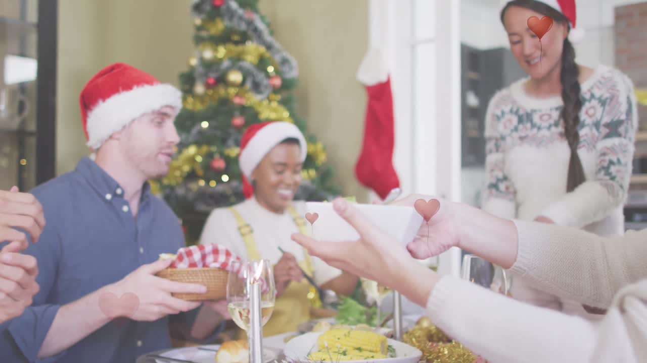 animación de los corazones sobre diversos amigos sentados a la mesa en navidad