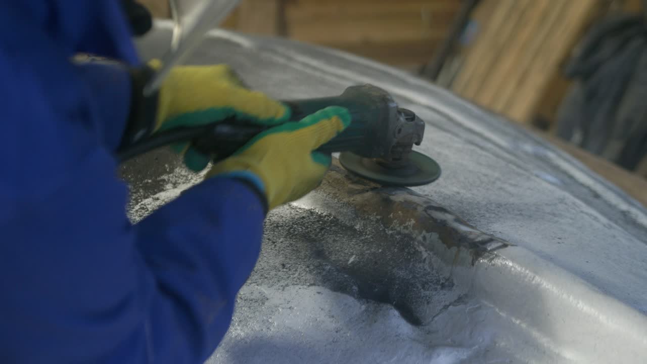 Slipa bort tätningsmedel från en glasfiberbåts kölband med en vinkelslip.