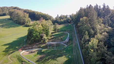 Fly-over-amusement-park-summer-toboggan-run-slope-on-sunny-day