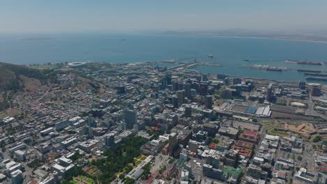 Aerial-panoramic-footage-of-buildings-in-city.-Harbour-and-sea-bay-in-distance.-Cape-Town,-South-Africa