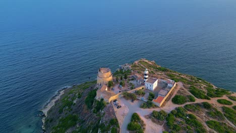 Calamosca-Turm-Mit-Dem-Angrenzenden-Leuchtturm,-Der-Den-Kleinen-Strand-Dominiert