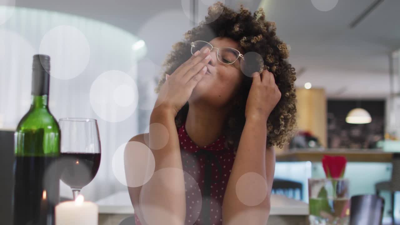 animación de spots sobre mujer afroamericana bebiendo vino y haciendo videollamas.