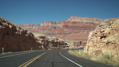 driving on state road in dry desert american landscape, driver's pov