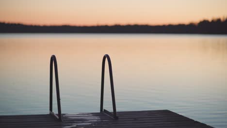 dock ladder on a wooden pier right after the sunset