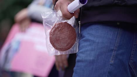 meat free cutlet. a man holds a packaged vegan cutlet. protest against eating food of animal origin.