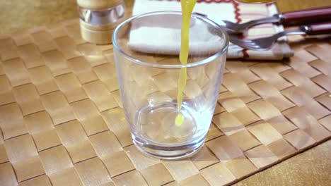 Orangensaft-In-Ein-Glas-Gießen,-Das-Morgendliche-Frühstück.-Zeitlupe-Mit-Rotierender-Kamerafahrt.