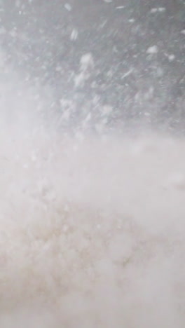 white powder bounces rhythmically on diaphragm of switched-on speaker. element of device moves under influence of electromagnetic field forming sound waves macro