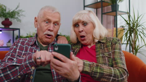 amazed senior grandparents use mobile smartphone receive good news message shocked by sudden victory