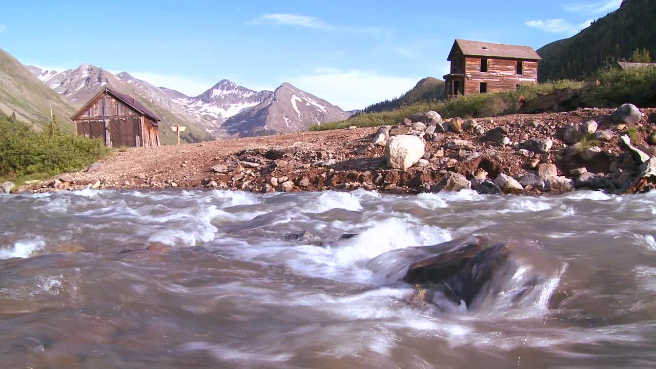 tiro de viaje a lo largo de un río con fondo de ciudad fantasma de colorado