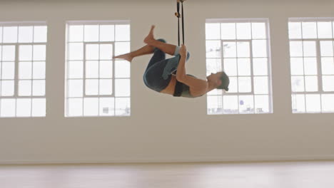 Aerial-Yoga-Frau-übt-Fliegende-Spagat-Pose-Mit-Kopfüber-Hängender-Hängematte-Und-Genießt-Einen-Gesunden-Fitness-Lebensstil,-Indem-Sie-Im-Studio-Trainiert-Und-Bei-Sonnenaufgang-Meditation-Trainiert