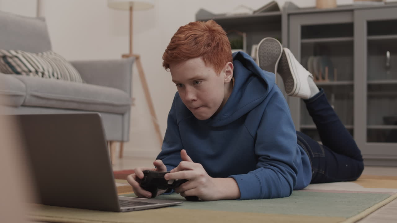 Teenager playing video games on laptop