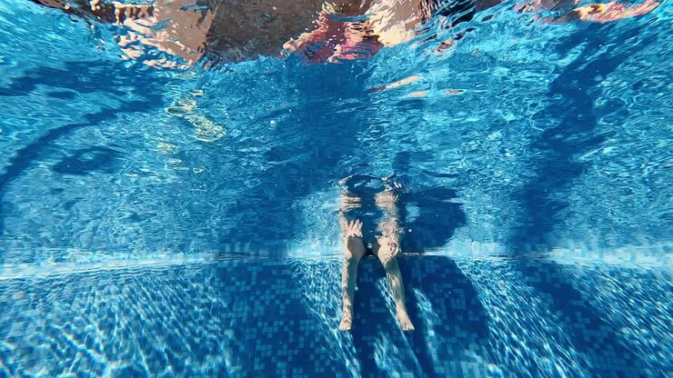 chica nadando bajo el agua en una pequeña piscina