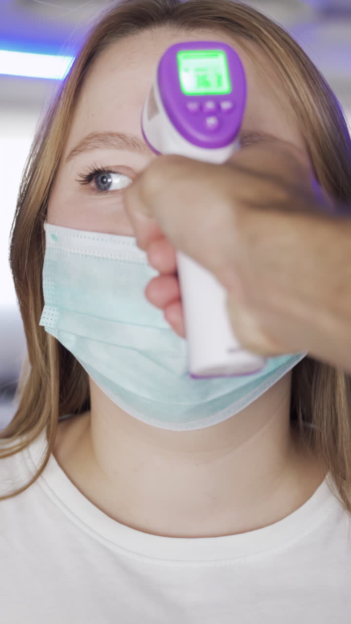 mujer sometida a un control de temperatura con una máscara