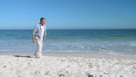 aged man walking alone on the beach