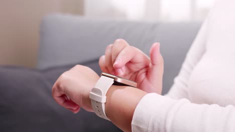 primer plano de una mano de mujer que toca y se desplaza en un reloj inteligente para verificar rápidamente la conexión de la aplicación