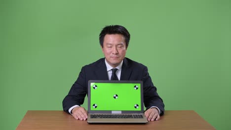 녹색 배경에 성숙한 일본 사업가