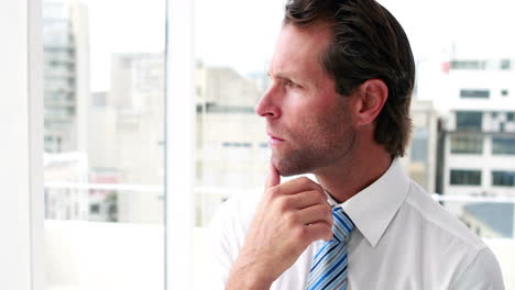 handsome businessman thinking and looking out window