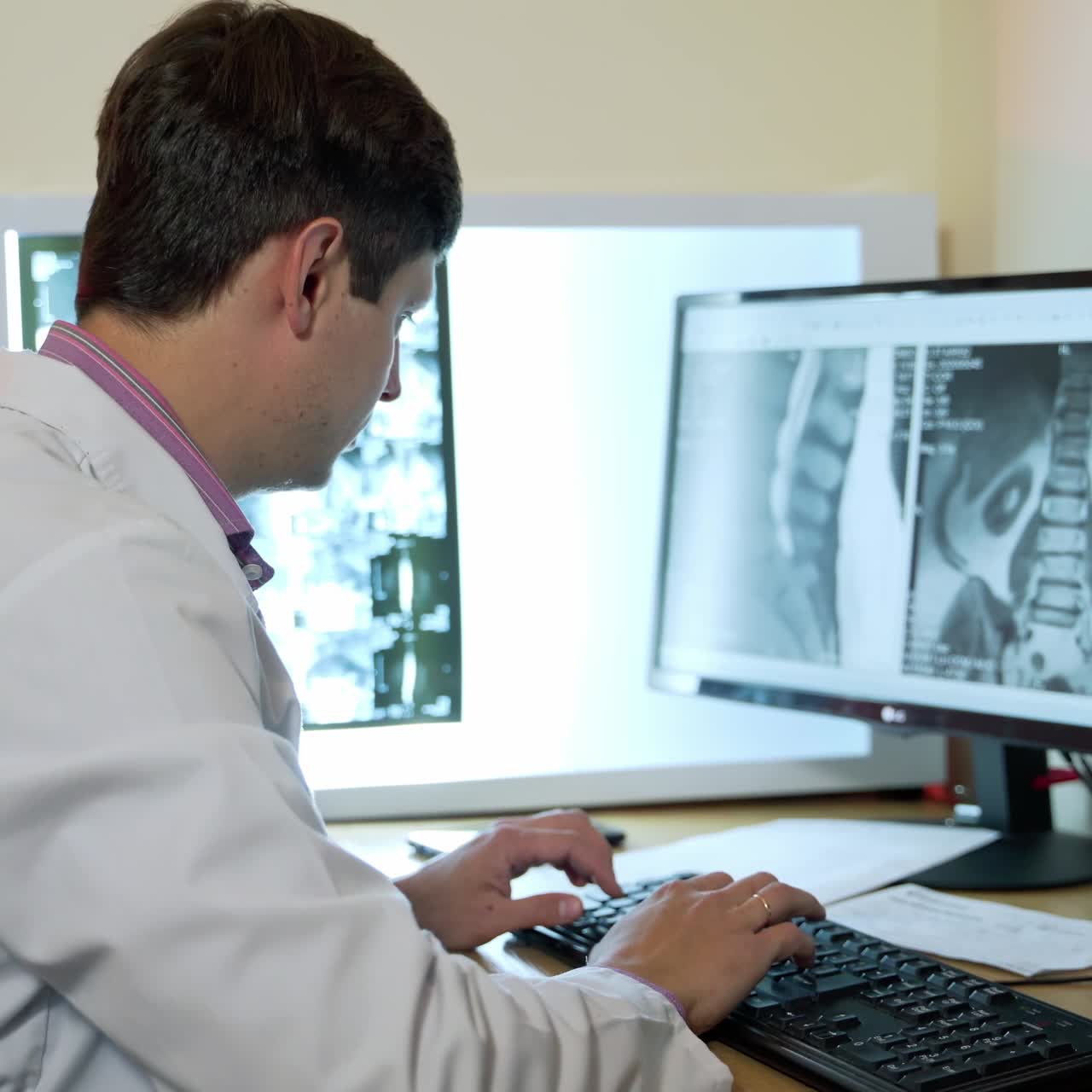 Young male doctor working on computer. Professional male doctor neurologist working with scans on computer