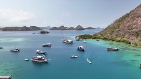 boats anchored in the turquoise waters off labuan bajo, indonesia, aerial view