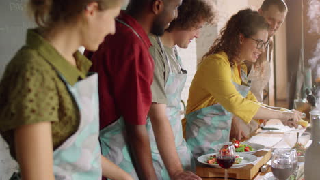 woman grating cheese on salad during cooking master class