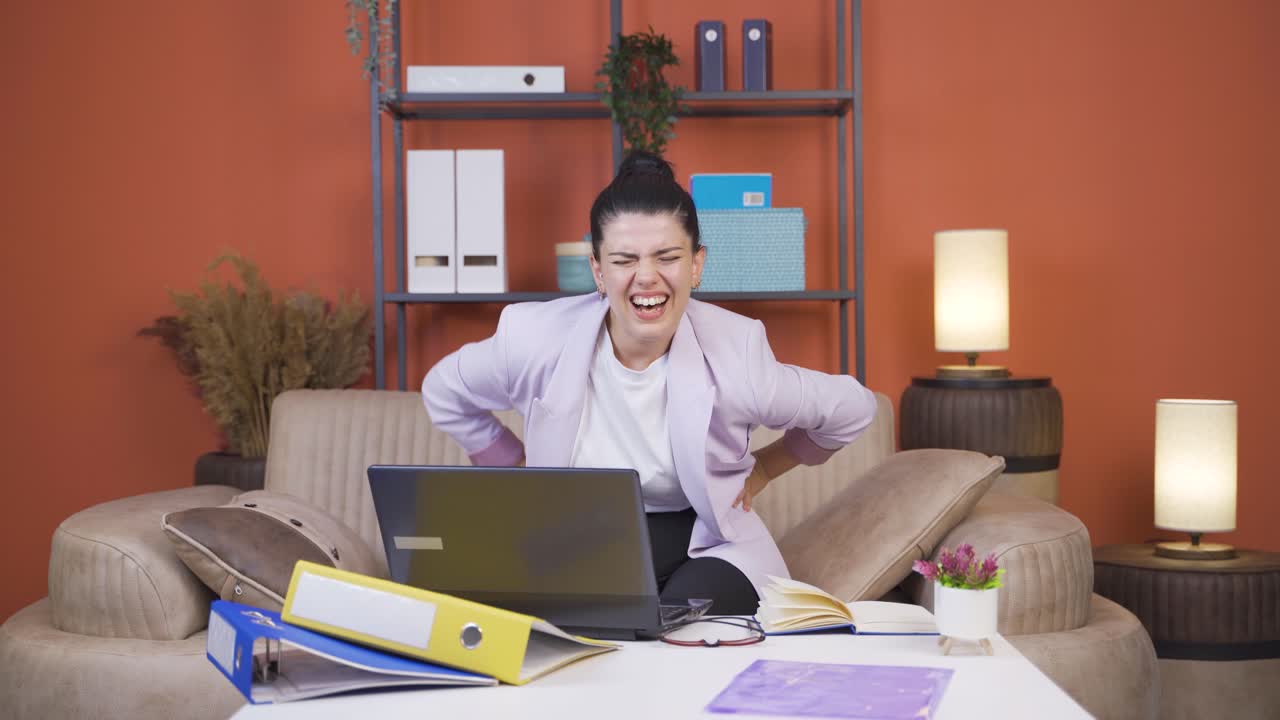 Home office worker young woman has lower back pain.