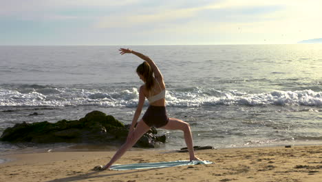 An-attractive-young-woman-practicing-yoga-on-a-beautiful-California-beach