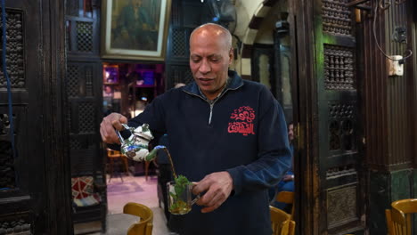 man pouring a herbal tea at coffee shops in cairo, egypt. - medium shot, slow motion