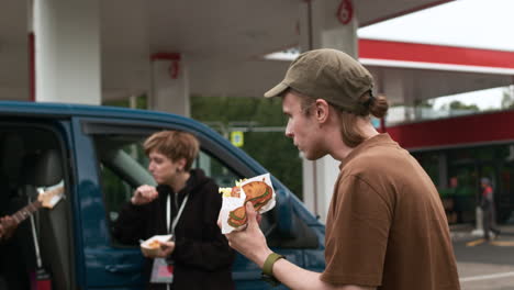 group resting on a gas station